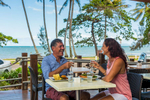 Mature couple enjoying lunch at a beachside cafe 