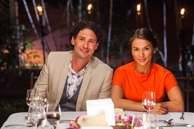 Portrait of My Kitchen Rules judges, Colin Fassnidge and Rachel Khoo sitting at dining table