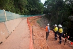 Constrcution workers standing on a section of highway undergoing slope stabilization works, Cairns