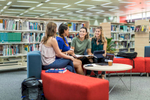 A group of tertiary education students talking together in the library