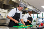 High school students practising food preparation skills in a commercial kitchen