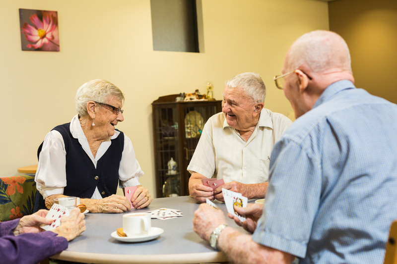 Elderly residents at a retirement village playing a game of cards 