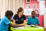 Teacher and aboriginal students reading in the classroom, Cape York 