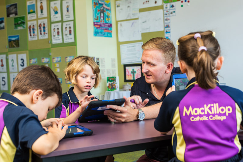 A teacher assisting students learning on iPads in the classroom