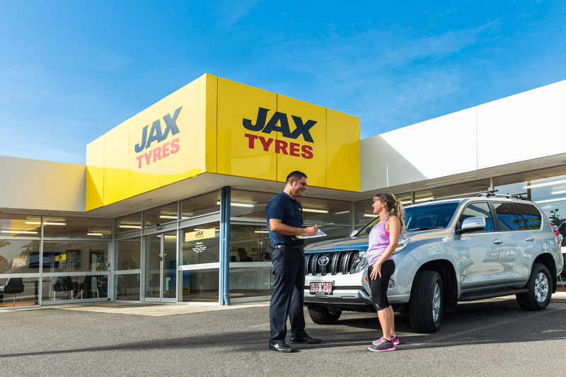 Tyre store manager talking to a customer with their vehicle at JAX Tyres in Cairns