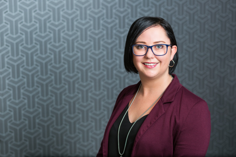 Headshot for female construction company administrator with patterned background, Cairns
