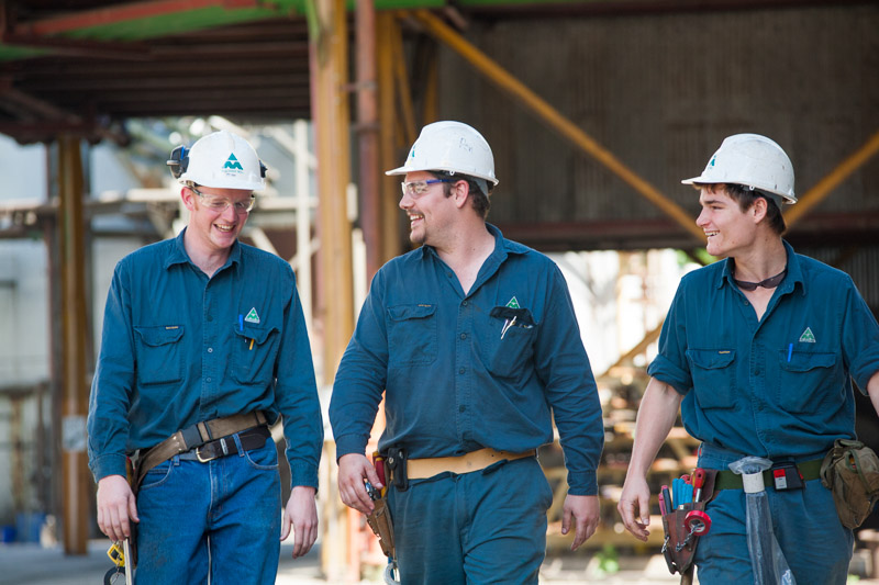 Three maintennace workers with hard hats and tool belts at a Sugar Mill, Cairns