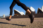 The Sydney Opera House framed by the legs of a morning jogger