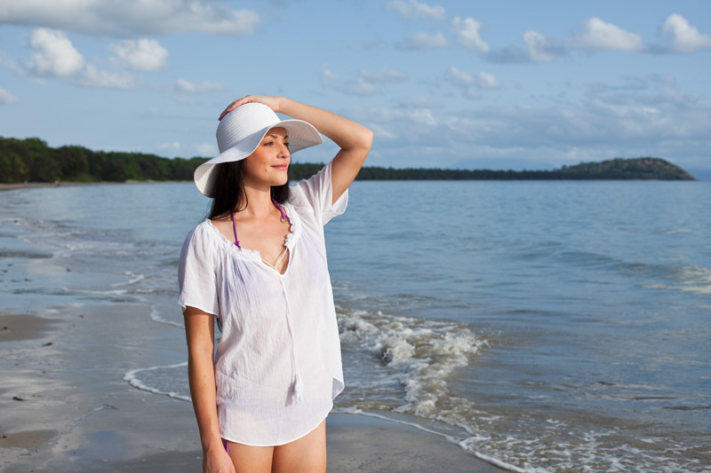 Young woman in beach wear looking along beach