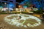 Children playing with light projections on the ground in Shields St, Cairns
