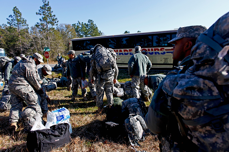 Soldiers gather their equipment after it was downloaded off the bus upon after arriving at Camp Blanding.
