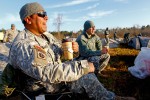 Sgt. Mateo enjoys some early morning coffee while sharing a joke with fellow soldiers.