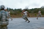 A group of soldiers race on the road for fun.