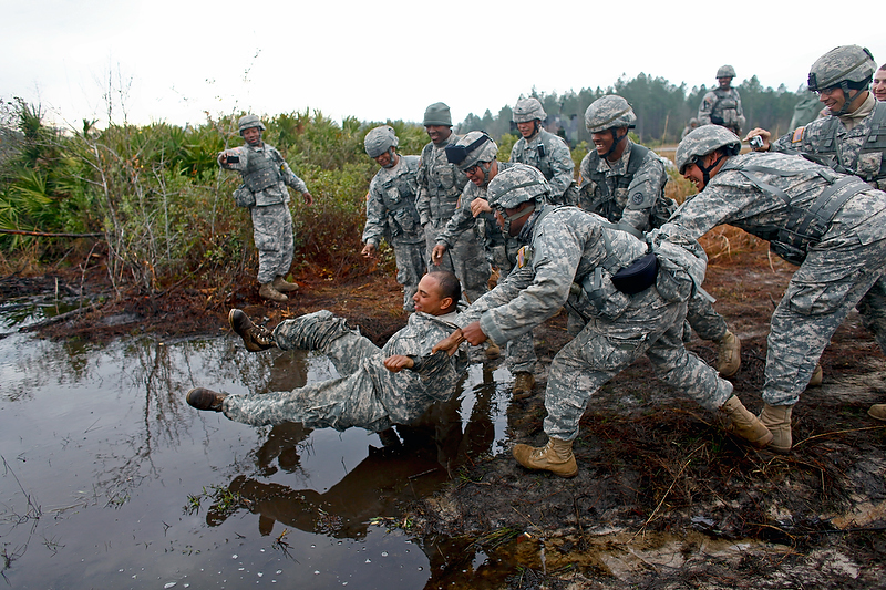 As part of his initiation into the battery, Pfc. Marte is thrown into a muddy pit.