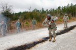 Staff Sgt. Brown does a celebratory dance as the unused gun powder is burned on the road. The powder burning signified the end of training.