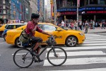 A man rides his bike while talking on his cell phone on 7th Avenue in Times Square, July 24, 2009.