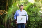 A portrait of Yashodan Heblekar with a painting of a white-breaster kingfisher at his home in Goa, India.
