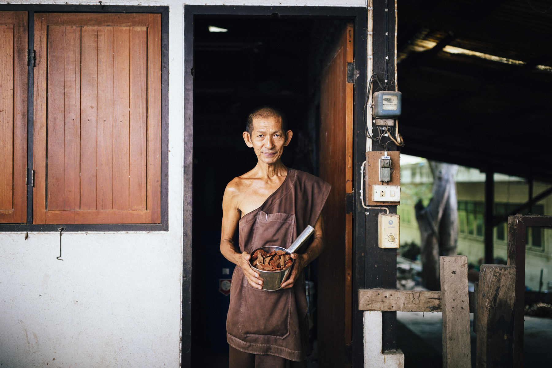 A monk holds out one of the countless ingredients in Tham Krabok's drug rehab elixir, which induces vomiting in the patients at the temple.