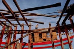 A man walks a plank at a boat construction yard in central Vietnam.