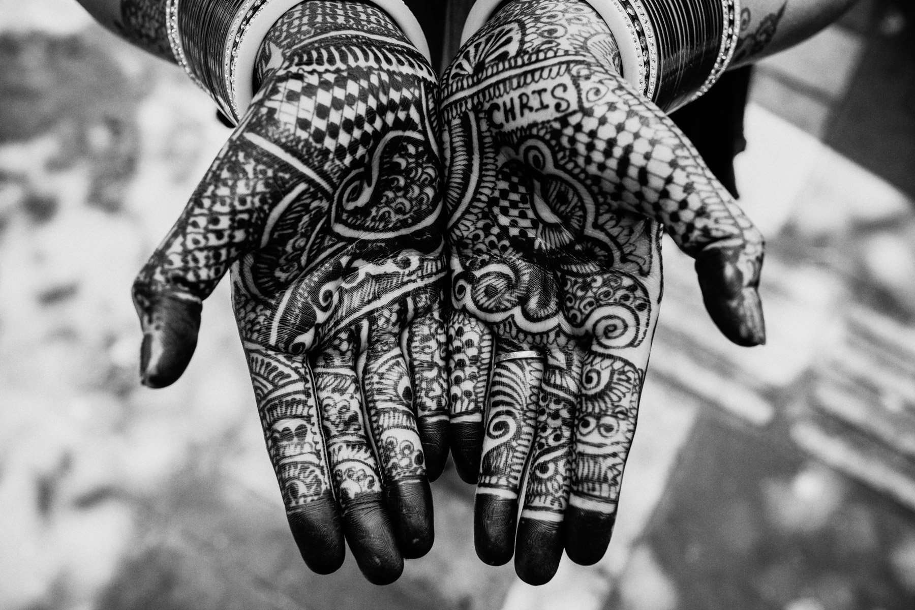 A young bride's Henna'd hands bearing her husband's name in Delhi, India.