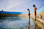 Young boys swim and dive at the Keerimalai Springs, sacred pools fed by sea waters on the northern shores of the Jaffna Peninsula in Sri Lanka.
