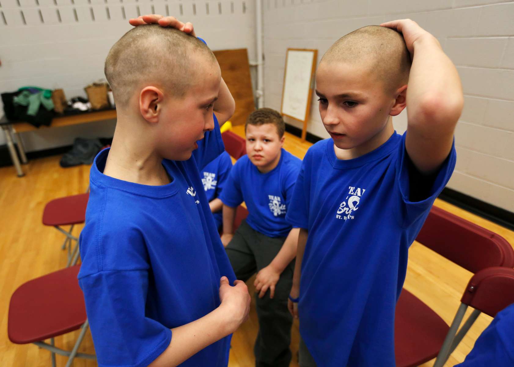 Corbin Migliaccio and Nate Porhacs check out their haircuts as students and faculty from Kennedy Elementary school shaved their head to raise money for St. Baldrick’s Foundation to help pediatric cancer research, at the school in Roxbury.