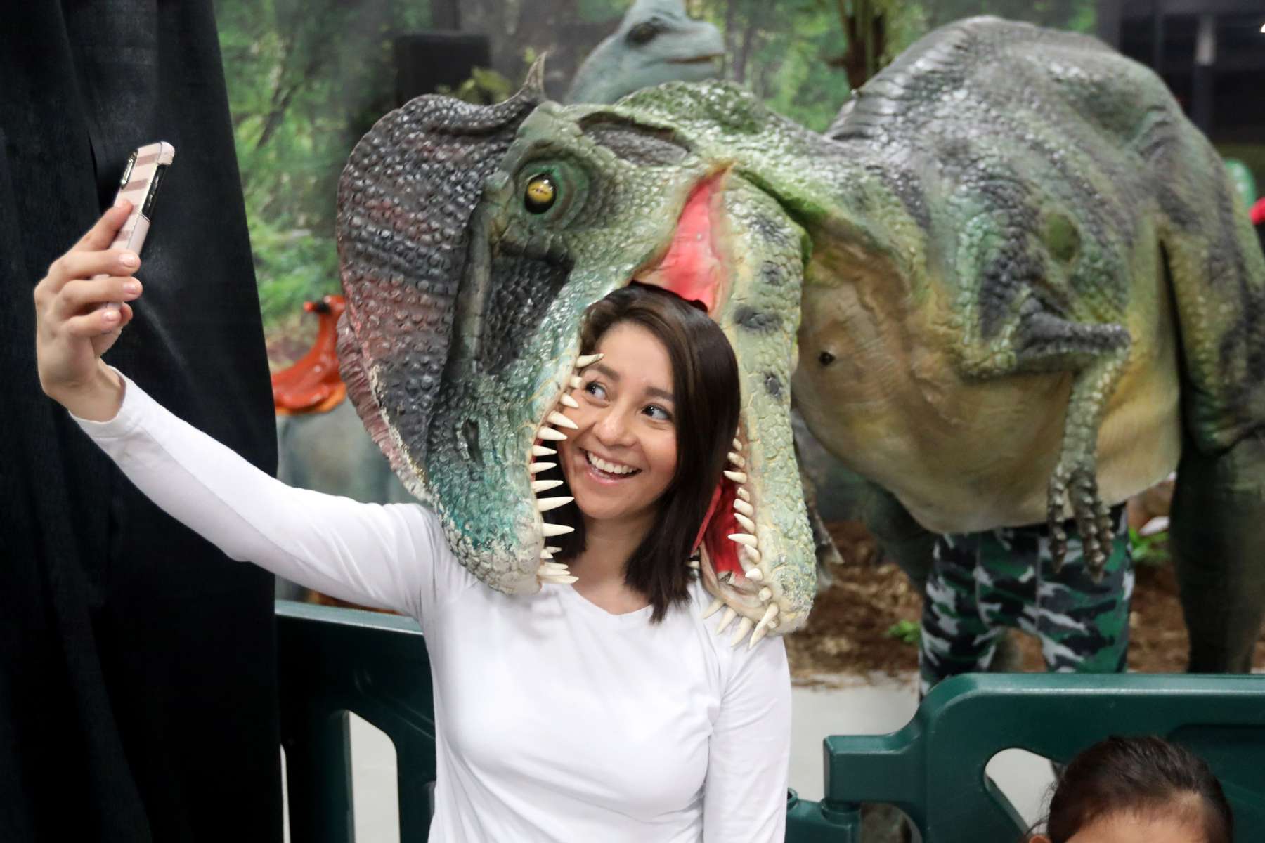 Elodia Villanueva take selfie with the Dilophosaurus dinosaur at Jurassic Quest, a dinosaur event, at the New Jersey Convention and Exposition Center in Edison.