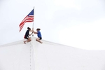 Ariel Staffin and Alanna Staffin try to post the American flag on one of the fair tents as the 69th Somerset County 4-H fair opened today at the North Branch Park 4-H Fairgrounds on Milltown Road in Bridgewater.