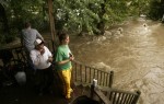 Tom Freeman, Donald Kise Jr. (sitting) and Autumn Widuto watch the Blair Creek swirl around Kise's home on Douglass in Blairstown during  flooding in Blairstown from Hurricaine Ivan.