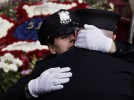 Newark Police officer Brandi McTighe embraces her brother and Newark firefighter Shannon McTighe in front of a Newark firetruck carrying flowers in the shape of a firefightrers badge after the funeral for  Newark firefighter and biker Ray Martinez at St. Lucy's Church in Newark on Saturday. 