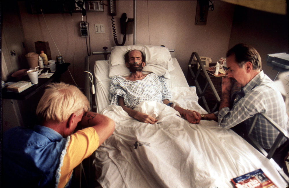 Volunteers sit with Peter as he nears death at the hospital.