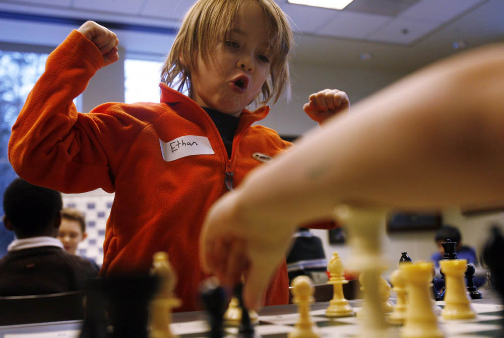 Ethan Cornett, 8 from Berkley Heights enjoys a move he made while playing against Sage Overbay 5, during the beginners chess class with Martin Sobin at the Bernardsville library. 
