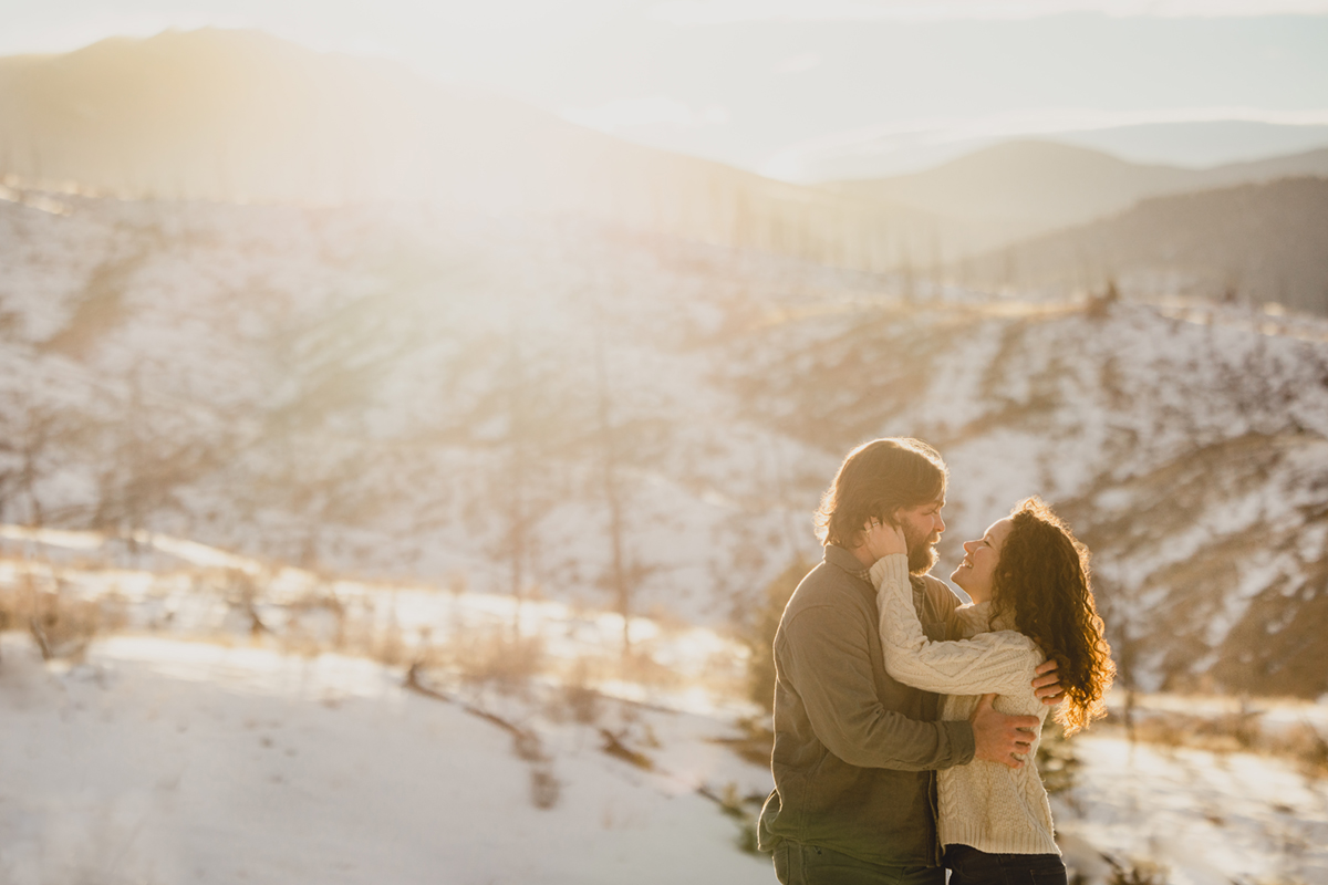 Couple poses for photographer during wedding engagement session in Colorado Rocky Mountains