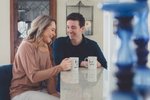 bride and groom sip coffee at kitchen counter during in home engagement photography session in Buffalo, NY