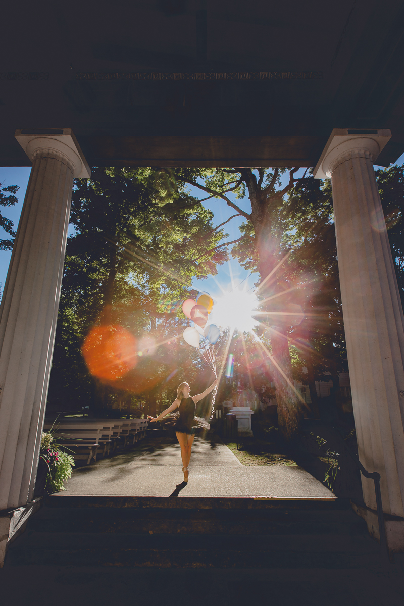 senior portrait by photographer Lindsay DeDario of maple grove high school student doing ballet on pointe with balloons in hand at Chautauqua Institute, a small town near Buffalo, NY in WNY 