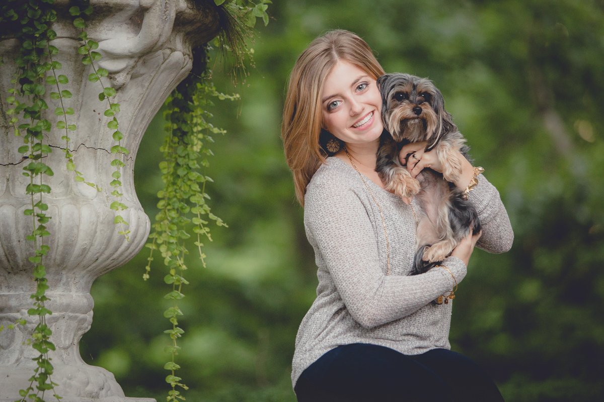senior portrait by photographer Lindsay DeDario of maple grove high school student with yorkie dog in her arms at Chautauqua Institute, a small town near Buffalo, NY in WNY 