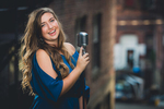 senior portrait by photographer Lindsay DeDario of maple grove high school student smiling with microphone in Jamestown, NY, a small city near Buffalo in WNY 