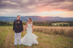bride and groom hold hands and look at each other on mountain top at sunset in the Adirondacks of NY
