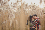 future bride and groom hug while touching foreheads among cat tails in field during their wedding engagement photography session at Tifft Nature Preserve in Buffalo, NY