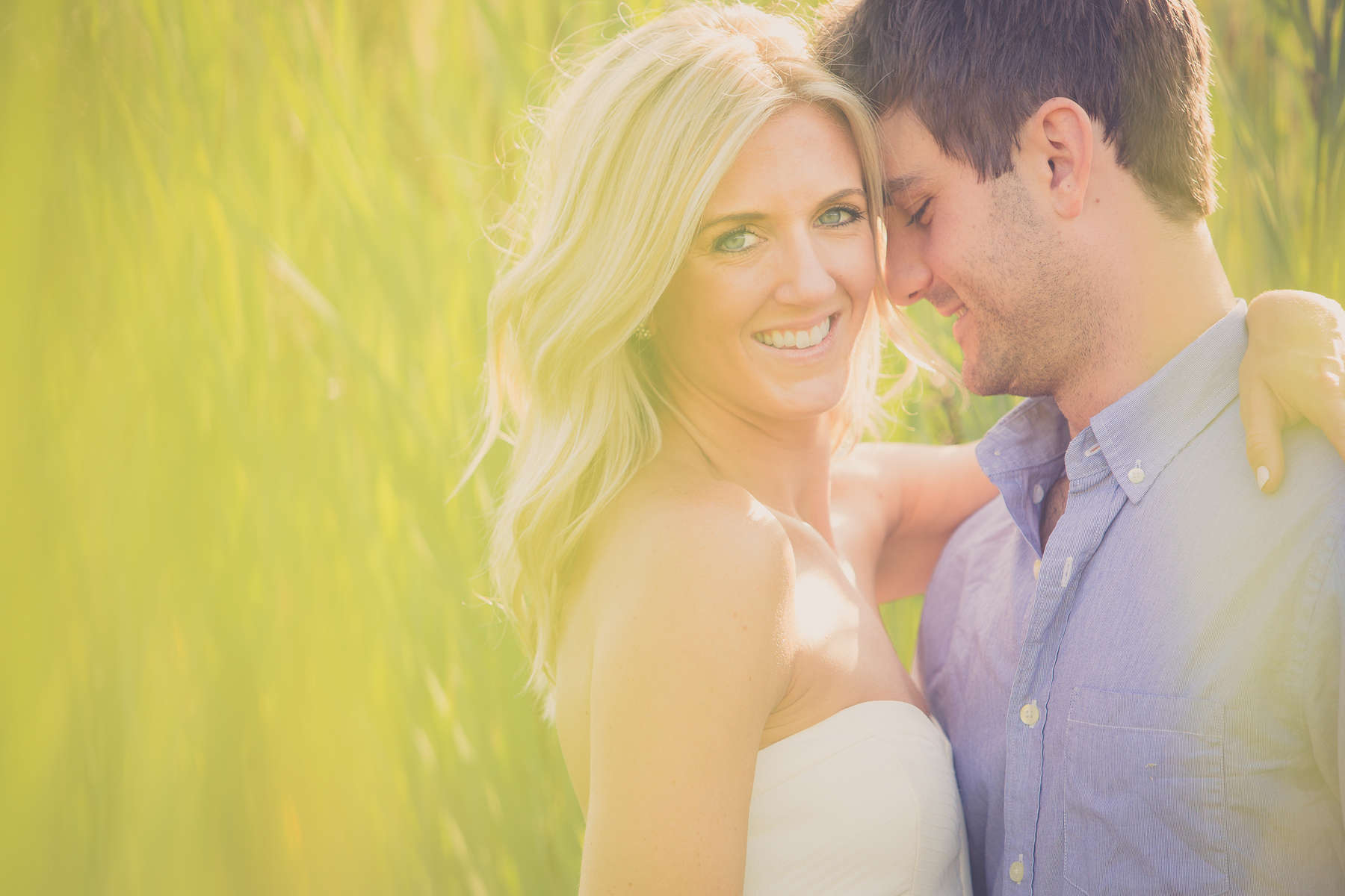engagement photography of groom looking at bride in field in buffalo ny at tifft nature preserve
