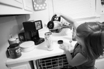 Zoey McCarver, 8-years-old, prepares a traveling mug of coffee for her mom, Caitlin Bell, before they leave for school and work on August 21, 2013 in Chattanooga, TN.