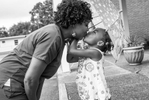Nikki Brown and her daughter Kristian, 4-years-old, share a moment under an umbrella outside church in Chattanooga, TN on August 21, 2013.