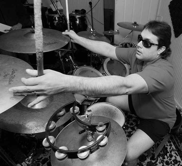 Marcus Padula, drummer for Deep Blue dJinn, quiets his cymbals during a demo session in Marlborough, MA. Padula, who is blind, has reversed the layout of the drum kit and cymbals typically used by drummers to allow him to play with greater speed and accuracy.