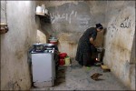 Nakam Amar, 23, cooks lunch in the kitchen of her home in the Al-Hurya section of Baghdad. Water must be boiled everyday to clear it of bacteria. 