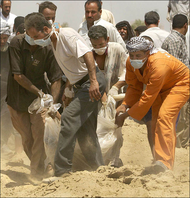 Bodily remains are removed from a mass grave discovered at a Iraqi intelligence base 30 miles south of Baghdad. 