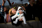 Children are offered up by their parents to Pope Francis for blessing at a general audience in Vatican City.