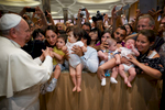 Children are offered up by their parents to Pope Francis for blessing at a general audience in Vatican City.