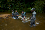 Andrew Wood, a former British SAS solder, now representing TAFFS (Television and Film Facilitation Services), center, stands with Honduran troops in a river while waiting for a team of scientists to catch up with them.