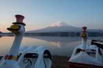 Framed by rental pedal boats, Mt. Fuji reflects in the waters of Lake Kawaguchiko at sunrise.