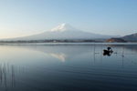 A local fisherman plies the waters of Lake Kawaguchiko, with Mt. Fuji as a backdrop.